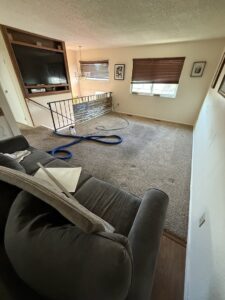 Before and after comparison of a carpeted area near a fireplace, showcasing professional cleaning by Hill's Magic Carpet Cleaning in Colorado Springs, CO.