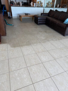 A tiled floor showing a clean section next to a dirty one, demonstrating tile cleaning by All American Carpet & Tile in San Diego, CA