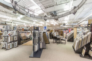 Beige and brown carpet samples on a display rack at Prosource of Erie, showcasing options in Erie, PA.
