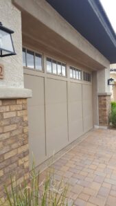 A stylish beige garage door with windows installed on a home by Absolute Garage Doors LLC AZ in Mesa, AZ