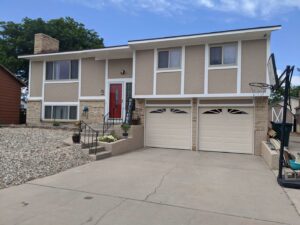 Two beige garage doors with windows installed on a home by Southern Colorado Garage Door in Pueblo, CO.