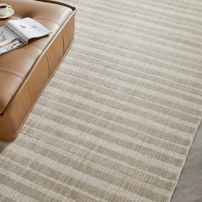 An overhead view of a light beige striped area rug in a living space by Artifacts Fine Rugs and Flooring in South Salt Lake, UT.