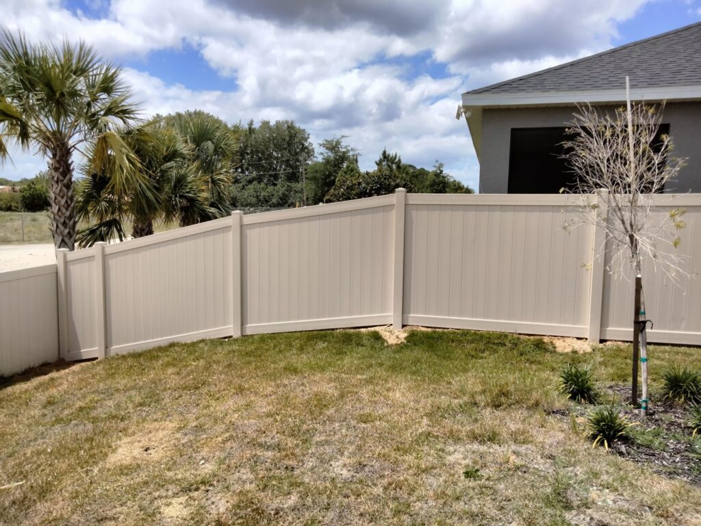 A beige vinyl fence enclosing a residential backyard, installed by Florida Professional Fence LLC in Altamonte Springs, FL.