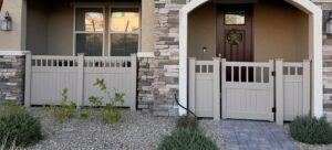 A beige vinyl fence and gate enclosing a front patio area, installed by Hirschi Iron in North Las Vegas, NV.