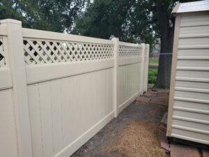 A beige vinyl privacy fence with a decorative lattice top installed by 5-Alarm Fence Company in New Orleans, LA.