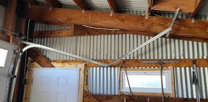A bent and broken garage door track, indicating a need for professional repair from Greeley garage door repair in Greeley, CO.