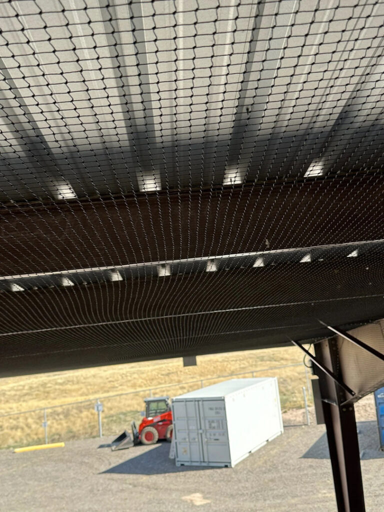 Newly installed bird and wildlife exclusion netting under a commercial roof by Montana Pest Solutions in Missoula, MT