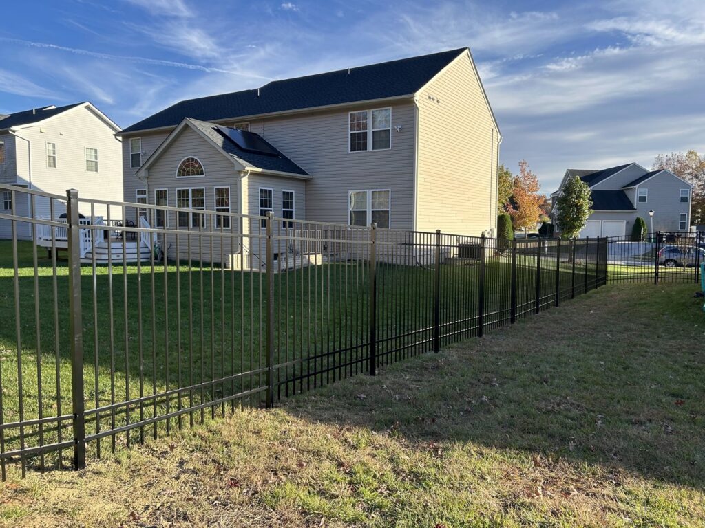 A sleek black aluminum fence enclosing a residential backyard, installed by AFK FENCE LLC in Waldorf, MD.