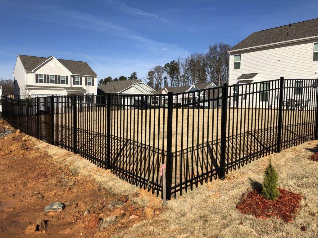 A new black aluminum fence enclosing a residential backyard by Fenceitforu LLC in Matthews, NC.
