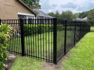 A black aluminum fence installed in a backyard around a residential property by Golden Eagle Fencing in Tampa, FL