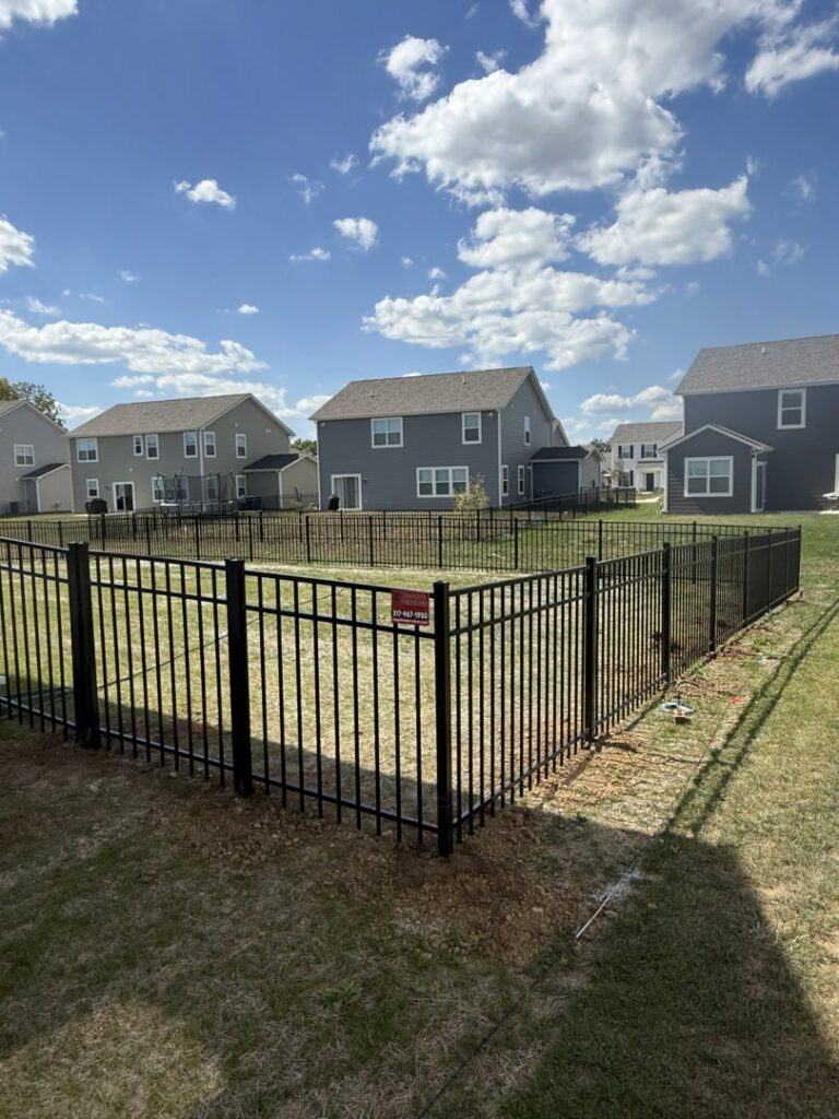 A black aluminum fence enclosing a section of a backyard, installed by Hoplite Services in Indianapolis, IN.