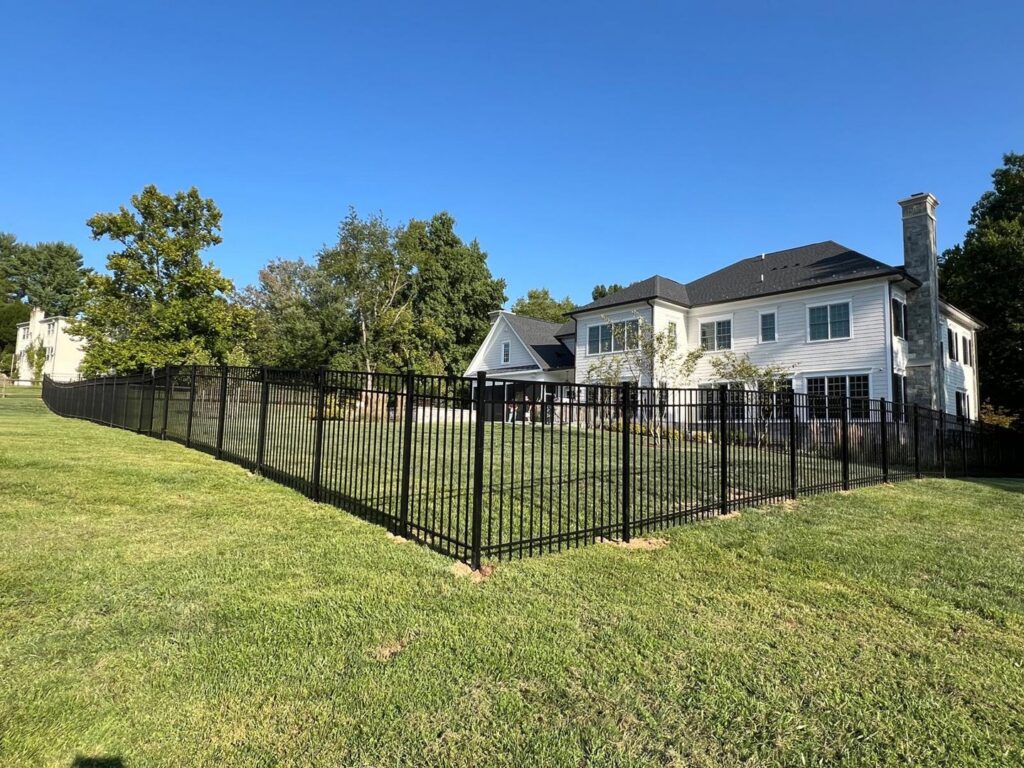 A large black aluminum fence enclosing a spacious backyard, installed by Master Fences in Gaithersburg, MD.