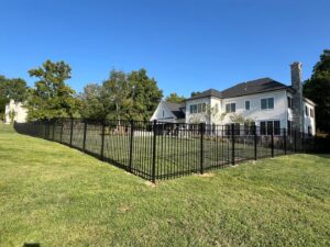 A large black aluminum fence enclosing a spacious backyard, installed by Master Fences in Gaithersburg, MD.