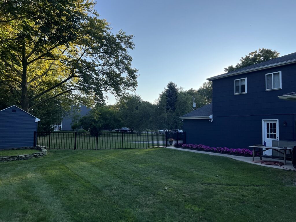 A newly installed black aluminum fence enclosing a residential backyard by MAC Fencing LLC in Toms River, NJ