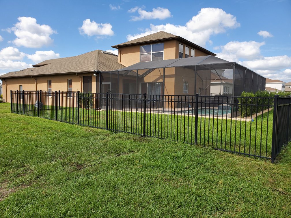 A black aluminum fence installed around a backyard with a pool cage by Big Jerry's Fencing of Boise ID in Holly Springs, NC.