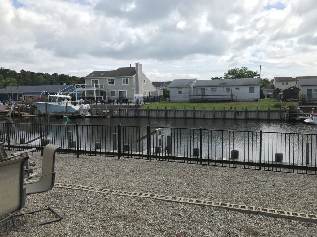 A black aluminum fence installed along a canal or waterway by MAC Fencing LLC in Toms River, NJ
