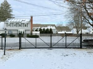 A robust black aluminum double gate installed in a snowy residential setting by Ultra Fence LLC in Brookline, NH.