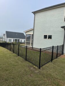 A black aluminum ornamental fence installed around the corner of a residential property by RDU Fence in Holly Springs, NC.