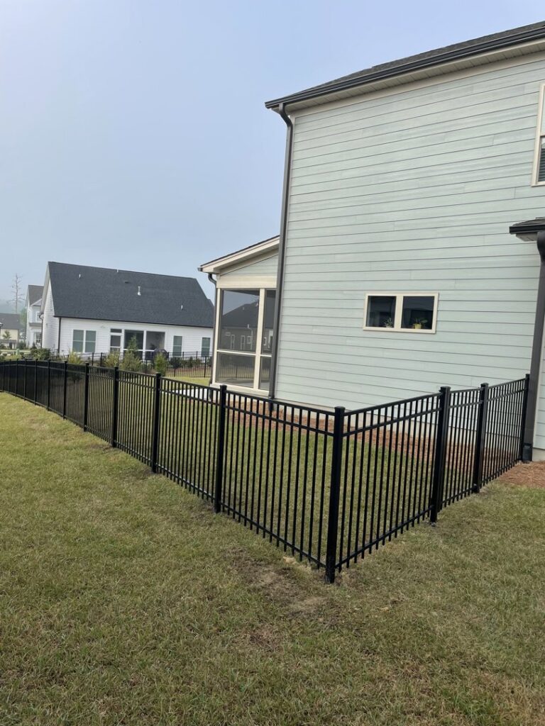 A black aluminum ornamental fence installed around the corner of a residential property by RDU Fence in Holly Springs, NC.