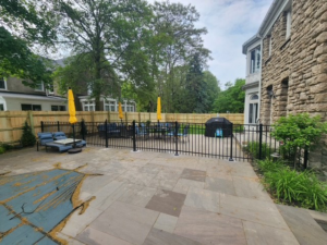 A black aluminum fence installed around a residential patio and pool area by City Fence Inc. in Lancaster, NY.