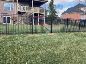 A sleek black aluminum fence enclosing a spacious backyard by ACE and Sons Fence Company in Evansville, IN.