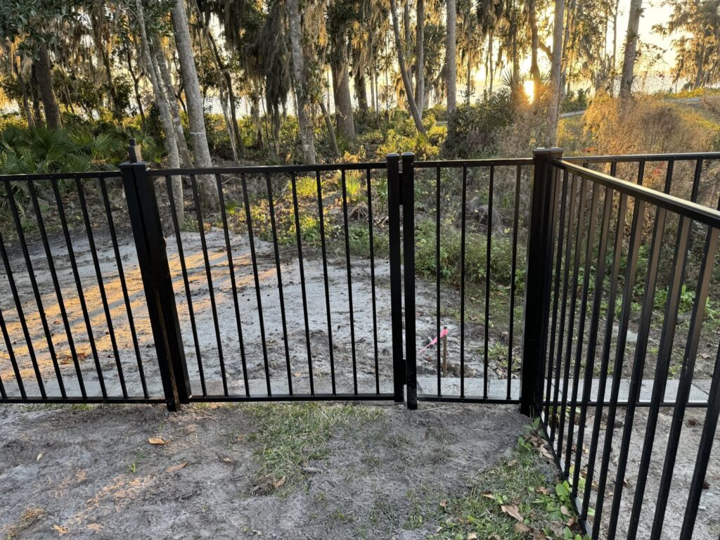 A black aluminum fence with a matching gate, expertly installed by Fence Nation LLC in Jacksonville, FL.