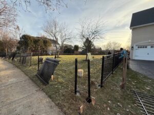 Black aluminum fence panels being installed in a residential yard by Cedar Mountain Fence Company in Plainfield, IL.