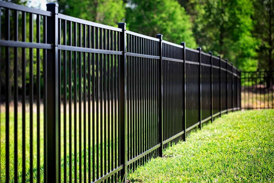 A newly installed black aluminum fence in a residential yard by Sumter Fence Company in South Sumter, SC.