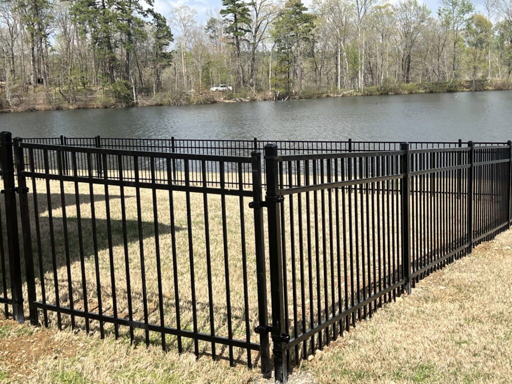 A black aluminum fence enclosing a lakefront yard, installed by Superior Fence and Rail of Little Rock, AR
