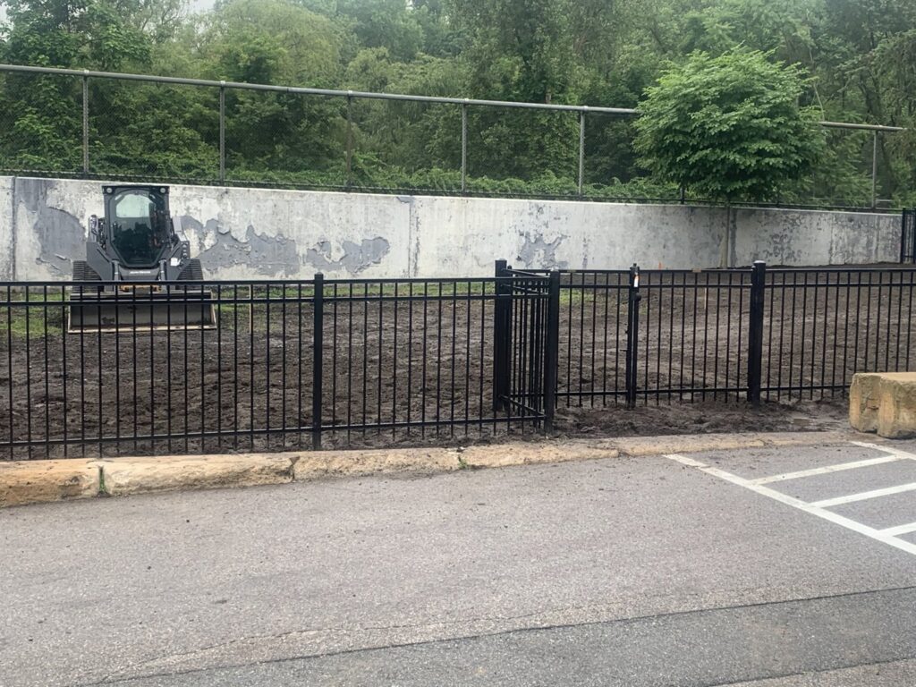 Black aluminum fence with a gate installed at a new construction site by Louis Fence installations & repairs in Fall River, MA