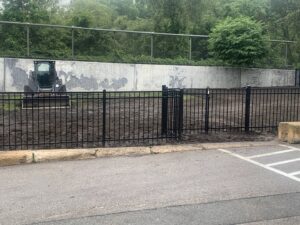 Black aluminum fence with a gate installed at a new construction site by Louis Fence installations & repairs in Fall River, MA