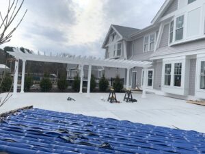 Black aluminum fence installed behind a white pergola by Louis Fence installations & repairs in Fall River, MA
