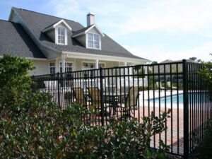 A black aluminum fence surrounding a poolside patio area by Frontier Fence LLC Bowling Green,Ky