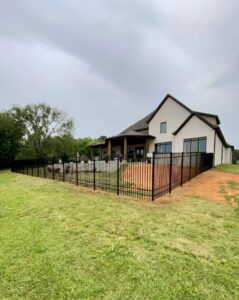 A black aluminum fence installed around a large residential property by TC Fencing LLC in Tuscaloosa, AL.