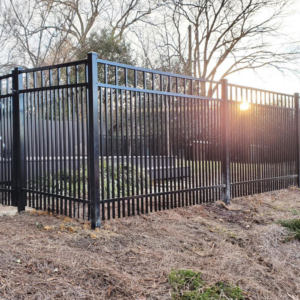 A black aluminum fence installed with the sun setting in the background by Outsiders Fencing in Greensboro, NC.