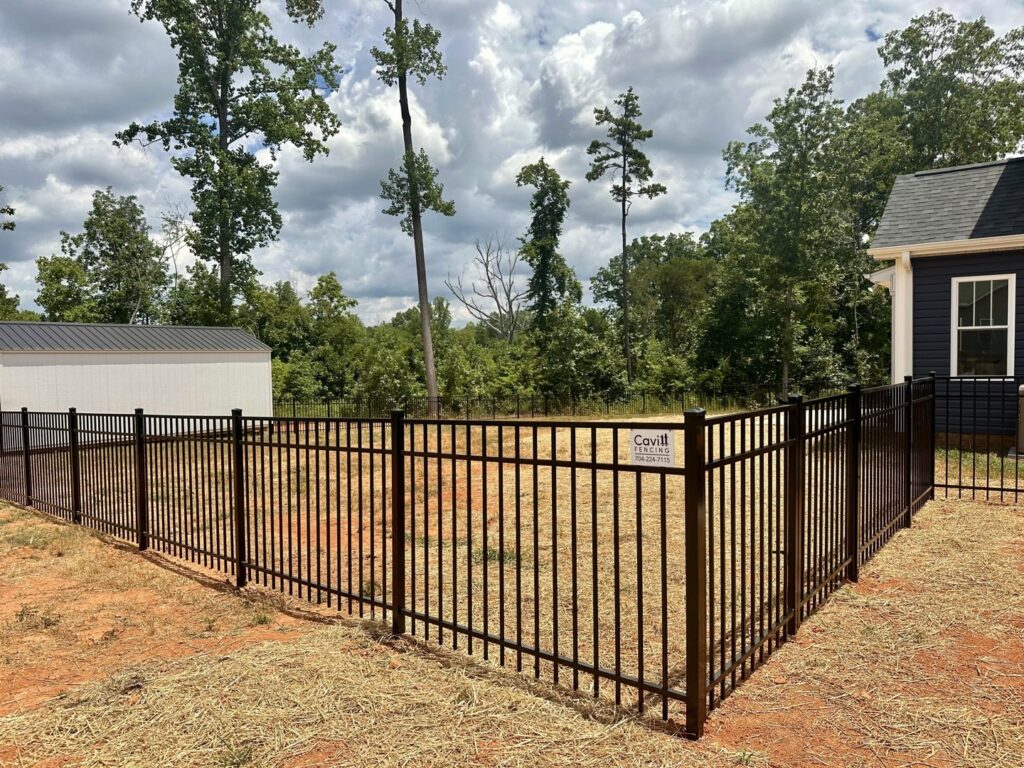 A black aluminum fence proudly displaying the Cavitt Fencing business sign, installed in Concord, NC.