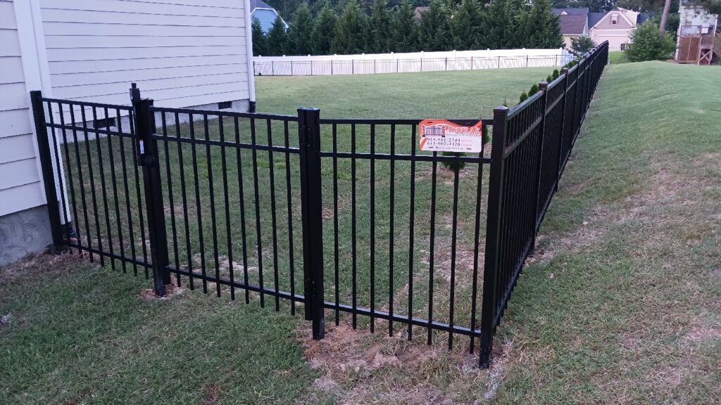 A durable black aluminum fence with a matching gate installed by Aguilarfence services LLC in Clayton, NC.