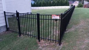 A durable black aluminum fence with a matching gate installed by Aguilarfence services LLC in Clayton, NC.