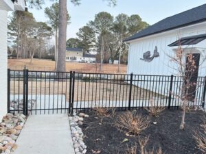 A newly installed black aluminum fence with a gate, providing security by Fast Fences LLC in Northfolk, VA.