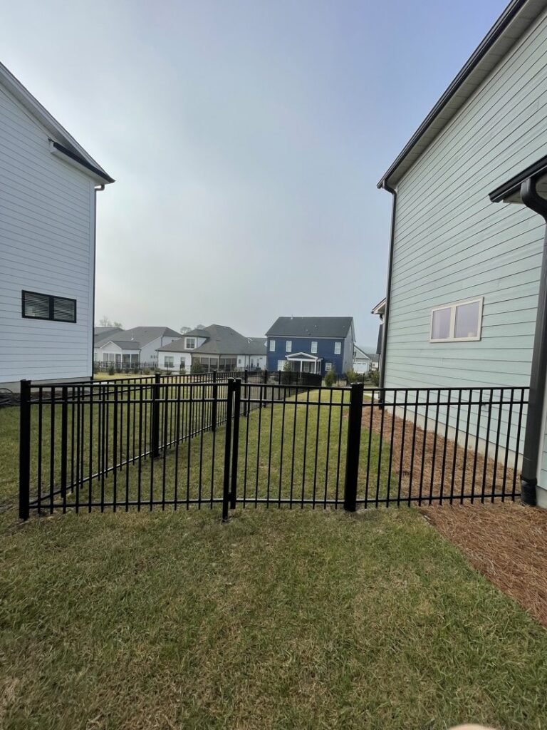 A black aluminum ornamental fence with a matching gate installed by RDU Fence in Holly Springs, NC.