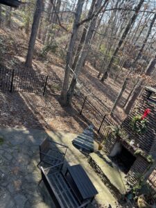 A black aluminum fence installed in a natural wooded backyard setting by Top Rail Fence Birmingham, AL