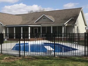 A black aluminum fence enclosing a swimming pool and backyard area by Frontier Fence LLC Bowling Green,Ky