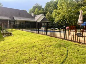 A sleek black aluminum fence installed around a swimming pool by First Responder Outdoor Construction LLC in Bartlett, TN.