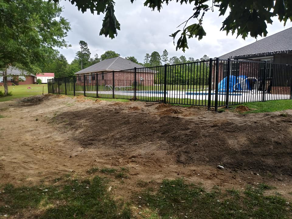 A newly installed black aluminum fence surrounding a swimming pool, completed by Country Boyz fencing in Biloxi, MS.
