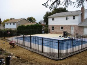 A black aluminum fence being installed around a swimming pool by Snyders Custom Fencing in York, PA.