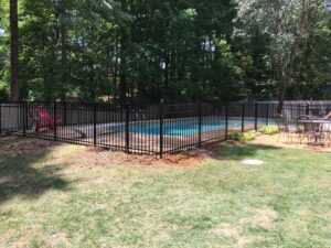 A black aluminum fence installed around a swimming pool for safety by Precision Fence in Meridian, MS.