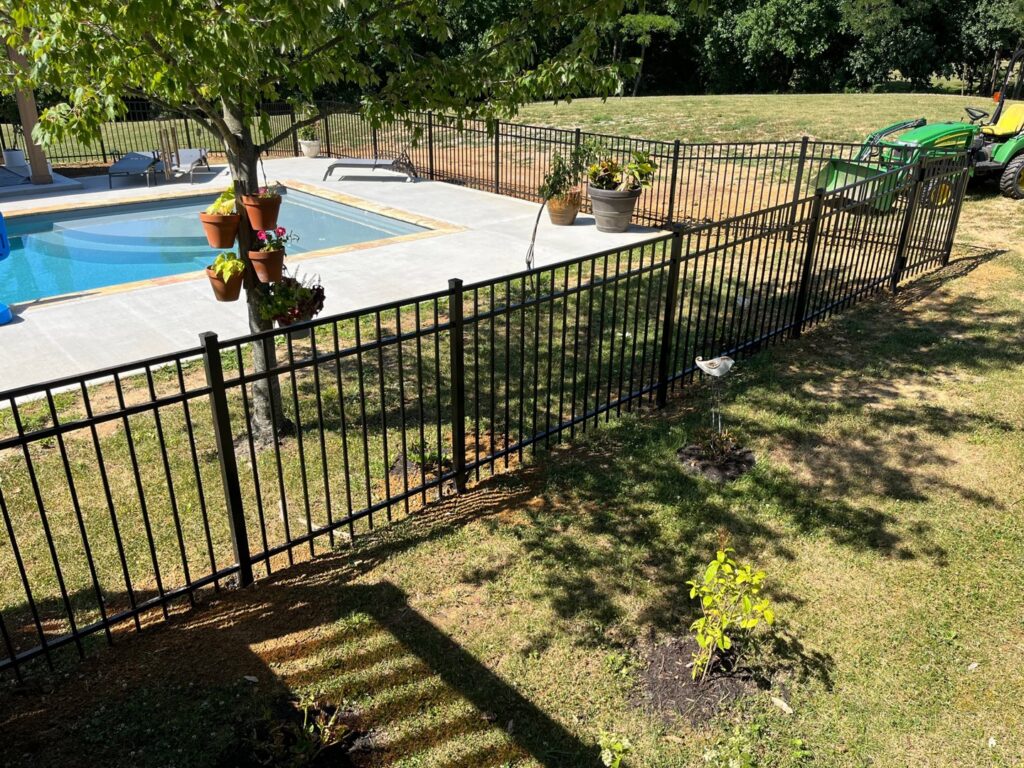 A sleek black aluminum fence installed around a swimming pool, ensuring safety and style by Roark Fencing in Lexington, KY.