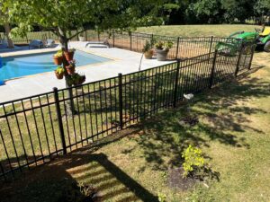 A sleek black aluminum fence installed around a swimming pool, ensuring safety and style by Roark Fencing in Lexington, KY.