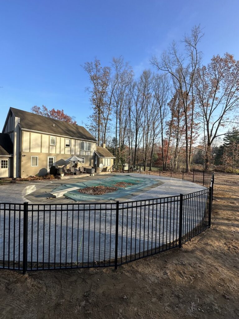 A black aluminum fence installed around a swimming pool, providing safety and style by Vision One Construction LLC in Schenectady, NY