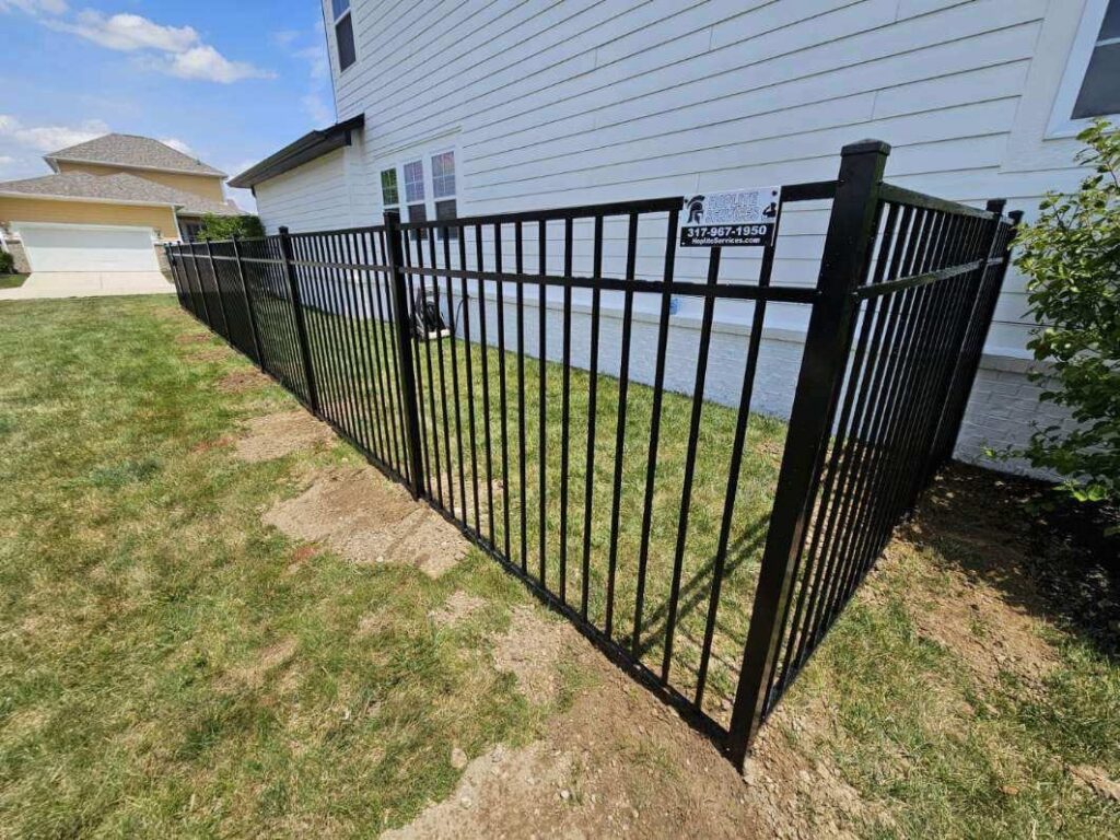 A black aluminum fence installed along the side of a house by Hoplite Services in Indianapolis, IN.